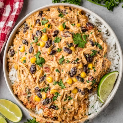 Ein Becher mit Rice und einer Mischung aus Gemüse, darunter Kartoffeln, Kokosnuss, Tomaten, Paprika und Zwiebeln.